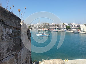 Beautiful view of boats in the sea with architectures in the background under blue sky