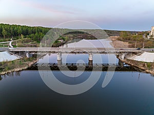 Beautiful view of the bridge across the Iset river in the city of Kamensk-Uralsky at sunset in spring. Kamensk-Uralskiy,