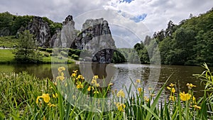 Beautiful view of a calm lake with trees and cliffs in the background under a cloudy sky