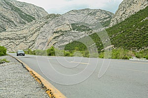 Beautiful view of car on asphalt highway in mountains. Road trip