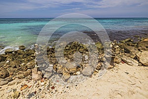 Beautiful view of Caribbean Sea with stones on sandy beach on island of Aruba on sunny day