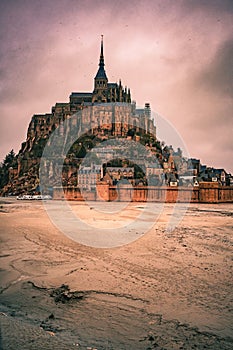 Beautiful view of a castle in Mont Saint-Michel Island in France under sunset cloudy sky