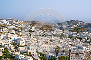 Beautiful view of Chora town of Mykonos at sunset, Greece. Whitewashed houses, hills, greenery, seafront, famous