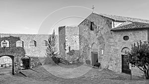 Beautiful view of the Church of San Giorgio in the historic center of Montemerano, Grosseto, Tuscany, Italy, in black and white