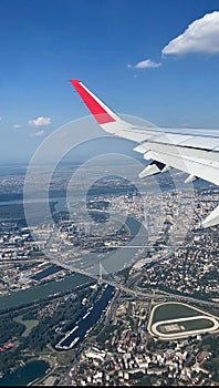 Beautiful view of the city from an airplane window from a bird& s eye view. Close-up of the tail of the plane, small