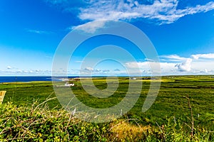 Beautiful view of a countryside with green grass, the sea in the background in the village of Doolin