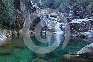 Beautiful view of a crystal clear water natural pool with the turquoise green background and rocks. Corga de Fecha, Lobios photo