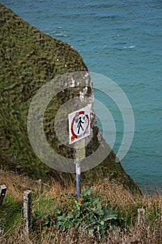 Beautiful view of a danger sign banning people to walk near the area of the Etretat cliffs