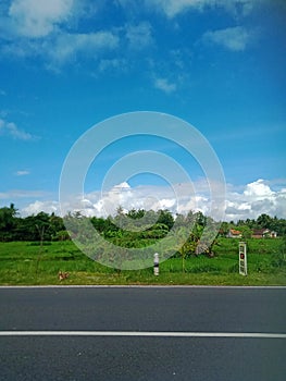 beautiful view during the day, full of color. blue sky with white clouds, green leaves from mountains, forests and agricultur