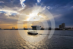 Beautiful view of Dubai Skyline in the evening. A boat or water taxi in the foreground. Dubai city during golden hour or sunset wi