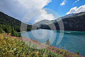 Beautiful view of the emerald alpine lake. Dramatic and picturesque scene. Mountain lake in the background of mountains and sky