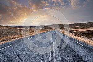 Beautiful view of empty road amidst volcanic landscape against sky during sunset