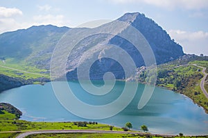 Beautiful view of Enol Lake in Covadonga Lakes, Asturias, Spain. Green grassland with mountains at the background