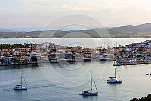 Beautiful view of Ermioni sea lagoon with moored yachts and boats at sunset time