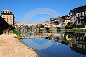 A Beautiful view of the famous Old Bridge Ponte Vecchio and Uffizi Gallery with blue sky in Florence as seen from Arno