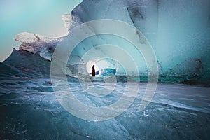 Beautiful view of female in dress posing in the glacier cave in Hofn, Iceland