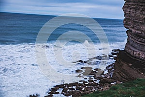 Beautiful view foamed wave in the coast  near the cliff