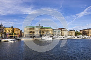 Beautiful view of grand hotel in the center of Stockholm on Baltic coast with ships moored to pier. Sweden.