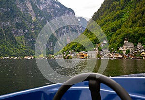 Beautiful View of the Hallstatt from lake Hallstater See, Austria with blue boat on the front popular tourist location