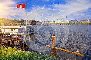 Beautiful view with Hamburg flag on sunny summer day at the Alster lake in Hamburg, Germany
