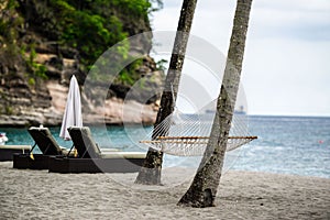 Beautiful view of hammock, beach chairs and umbrella on St. Lucian beachside in front of the sea