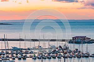 Beautiful view of a harbor with docked boats and ships during sunrise