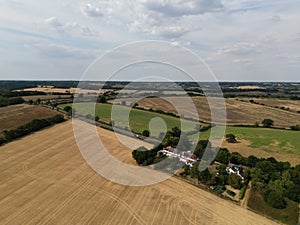 Beautiful view of harvested fields and road with green trees under the cloudy sky