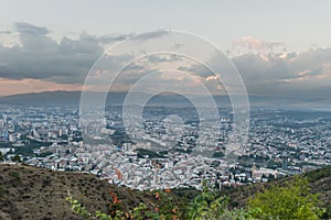 Beautiful view from the hill on big city with mountains afar