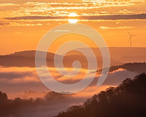 Beautiful view of the hills with a distant wind turbine at sunset