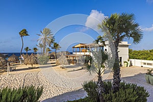 Beautiful view of the hotel\'s sandy beach area in the Caribbean Sea with a volleyball court and restaurant.
