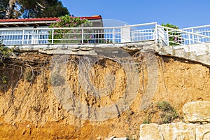 Beautiful view of house with white metal fence on cliff edge.