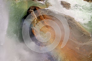 Beautiful view of a huge rock and waterfall with steam and sunbeams