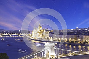 Beautiful view of the Hungarian Parliament and the Szechenyi chain bridge across the Danube in the panorama of Budapest at night