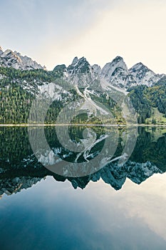 Beautiful view of idyllic colorful autumn scenery with Dachstein mountain summit reflecting in crystal clear Gosausee mountain