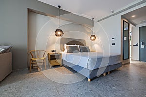 Beautiful view of the interior of the hotel room with a bed, bedside tables and lighting.