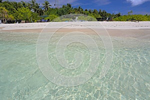 Beautiful view of island in Indian Ocean, Maldives. Turquoise water, white sand beach and green trees on blue sky background