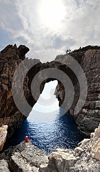 Beautiful view of the Korakonissi Tourist attraction and a female sitting on a rock