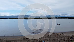 Beautiful view of a lake with boats and mountains in a background