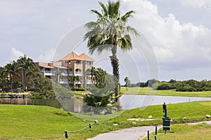 Beautiful view of lake and golf course on blue sky with white clouds in background.