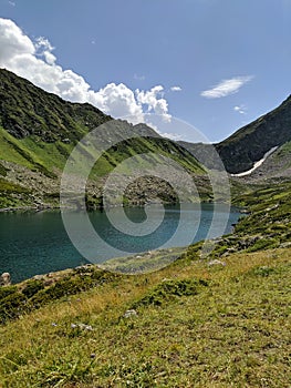 Beautiful view of the landscape of the Caucasus Mountains against a blue sky with clouds. View of the transparent Dukkinsky lake