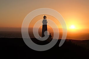 Beautiful view of a lighthouse on a shore during orange sunset