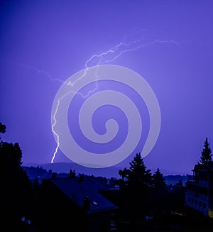 Beautiful view of the lightning over a landscape with trees and buildings
