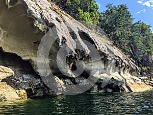 A beautiful view of a long shoreline of sea caves caused by coastal erosion on wallace island, in the gulf islands