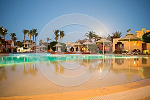 Beautiful view of the luxurious hotel pool in the moonlight. Rest area at an expensive resort. Swimming pool at night in one of