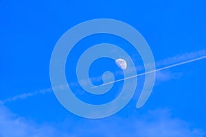 Beautiful view of a moon still visible on the vibrant blue sky during daytime