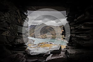 Beautiful view of mount Snowden landscape through window of abandoned miners bothie cottage in Dinorwic slate quarry North Wales.