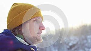 A beautiful view of the mountains in winter. A Young Man is Walking Up Mountain Slope. The handsome man is looking over