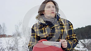 A beautiful view of the mountains in winter. A Young Man is Walking Up Mountain Slope. The handsome man is looking over