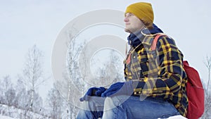 A beautiful view of the mountains in winter. A Young Man is Walking Up Mountain Slope. The handsome man is looking over