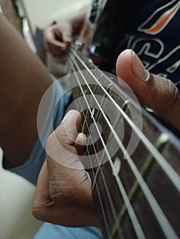 Beautiful view of musical instruments electric Guitar with young man fingers